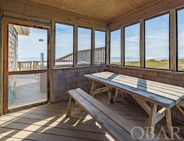 sunroom / solarium featuring a water view and a healthy amount of sunlight