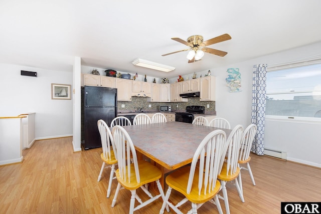 dining space with a baseboard heating unit, ceiling fan, light wood finished floors, and baseboards