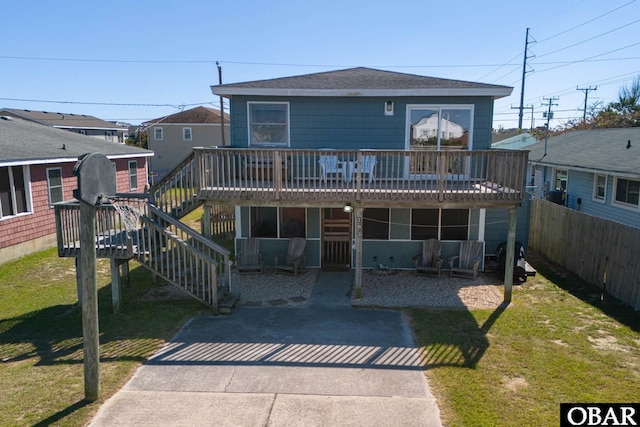 view of front of home featuring a deck, a front yard, and stairway