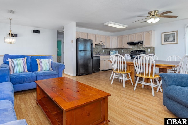 living room with visible vents, light wood-style flooring, and ceiling fan with notable chandelier