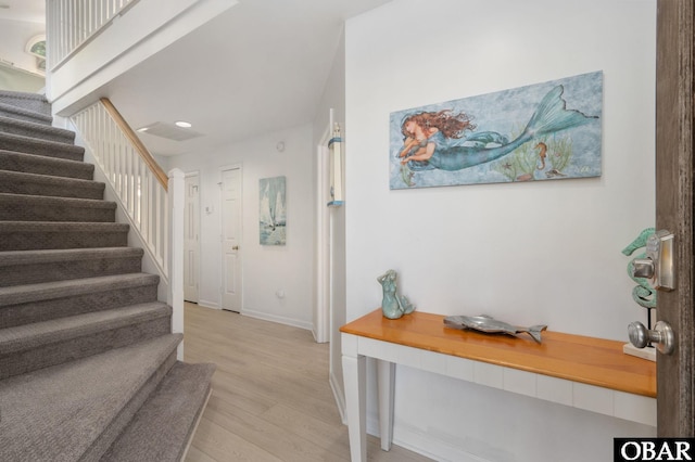 entrance foyer with light wood-style floors, baseboards, and stairway