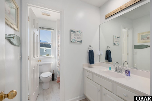 full bath featuring toilet, vanity, and visible vents