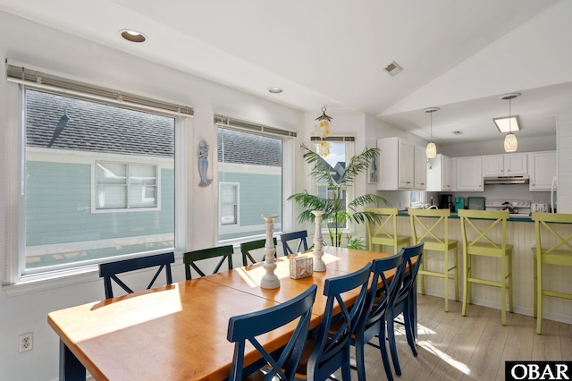 dining space with lofted ceiling, visible vents, light wood finished floors, and recessed lighting