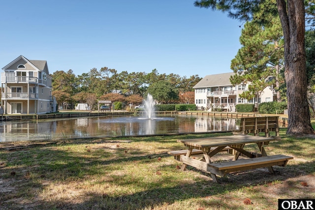 surrounding community featuring a water view and a yard