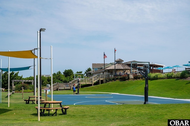 view of basketball court with community basketball court and a yard