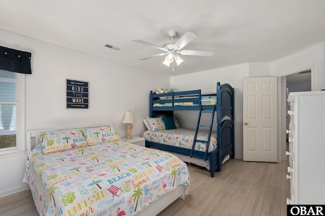 bedroom with light wood-style flooring, visible vents, ceiling fan, and baseboards