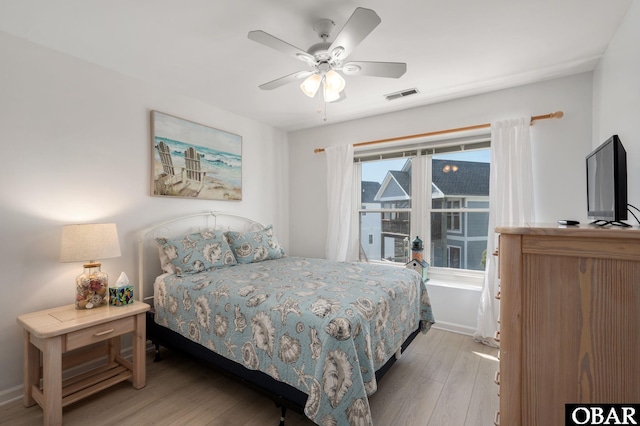 bedroom with visible vents, ceiling fan, baseboards, and wood finished floors