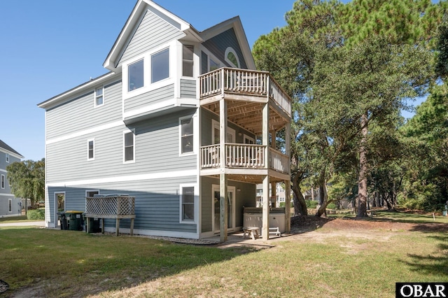 back of property with a deck, a sunroom, a lawn, and a hot tub