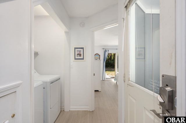 washroom with washer and clothes dryer, light wood-type flooring, and baseboards