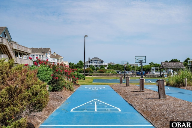 view of home's community with shuffleboard, community basketball court, and fence