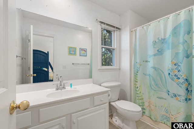 full bath with a shower with shower curtain, vanity, and toilet