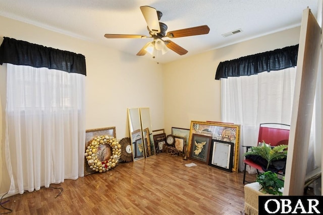 interior space with wood finished floors, visible vents, and a ceiling fan