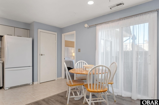 dining room featuring light tile patterned floors, visible vents, and baseboards