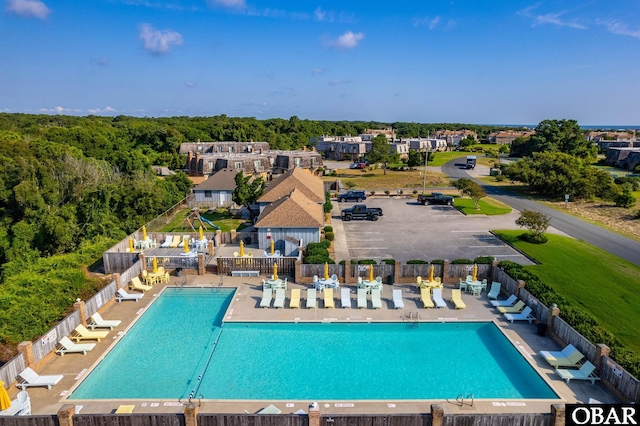 community pool with a patio and fence