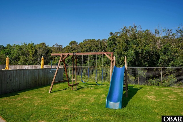 view of playground featuring a lawn and a fenced backyard