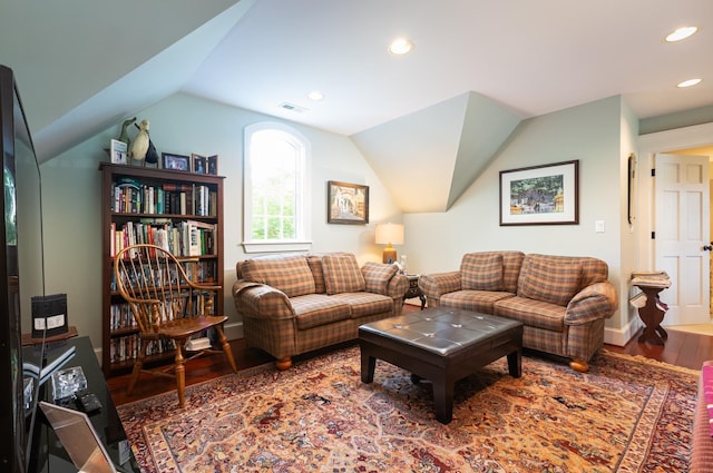 living room featuring wood finished floors, visible vents, baseboards, lofted ceiling, and recessed lighting