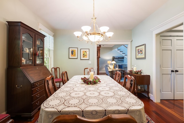 dining room with stairway, dark wood-style floors, baseboards, and a chandelier