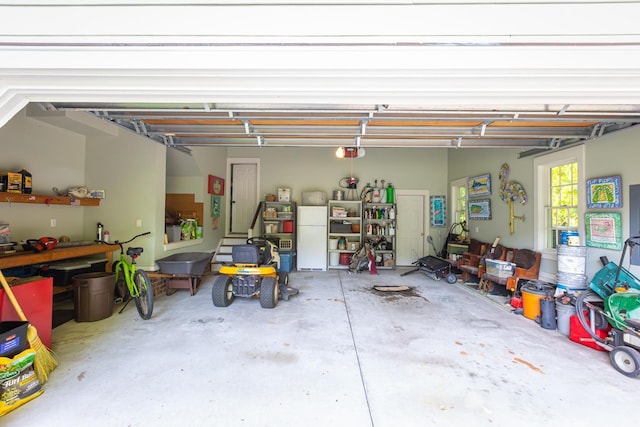 garage with freestanding refrigerator and a garage door opener