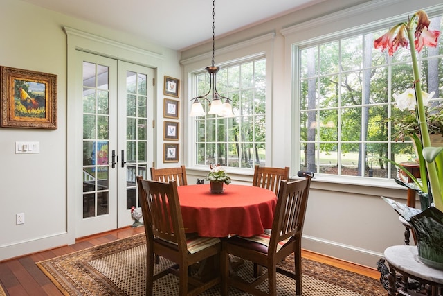 dining space featuring french doors, plenty of natural light, baseboards, and wood finished floors