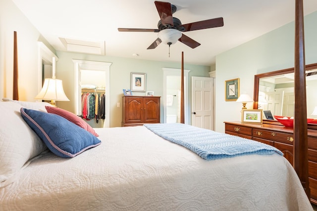 bedroom featuring a walk in closet, a ceiling fan, attic access, and a closet