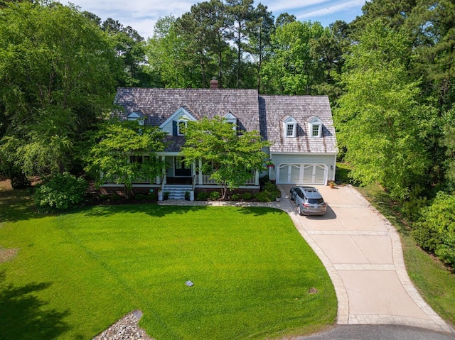 new england style home with a garage, concrete driveway, and a front yard