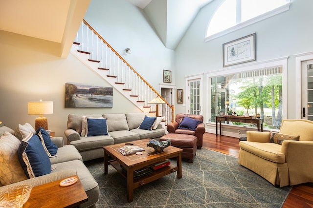 living area with a wealth of natural light, wood finished floors, and stairs