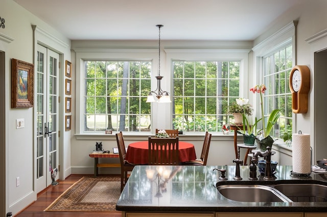 sunroom / solarium with a notable chandelier and a sink