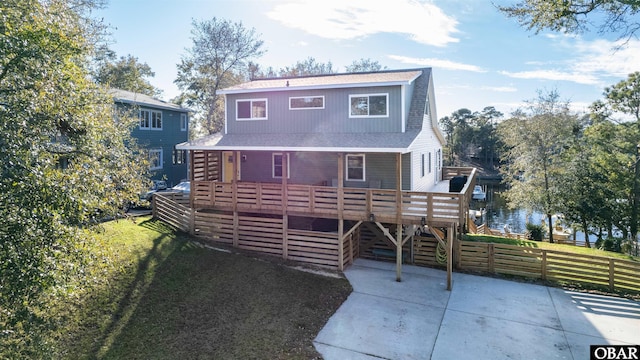 view of front of property with a shingled roof, a wooden deck, and fence