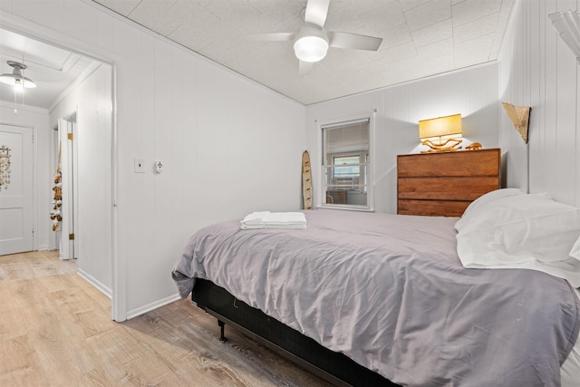 bedroom with light wood-style floors, attic access, ornamental molding, ceiling fan, and baseboards