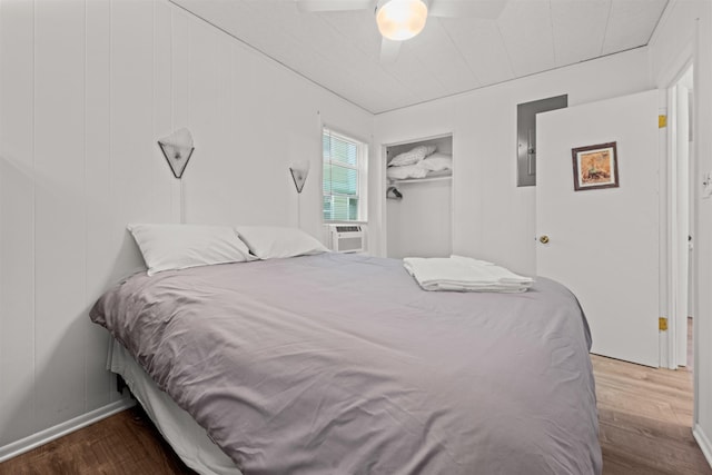 bedroom featuring ceiling fan, a closet, cooling unit, and wood finished floors