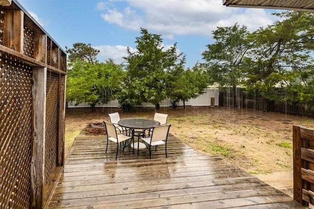 wooden deck featuring outdoor dining area and a fenced backyard