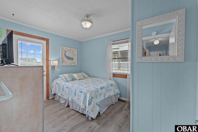 1400 N Virginia Dare Trl, Kill Devil Hills, NC 27948 - bedroom featuring ornamental molding, wood finished floors, a textured ceiling, and baseboards