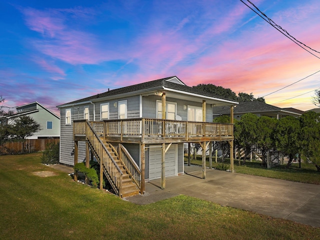 view of front facade with concrete driveway, stairway, an attached garage, a yard, and a carport