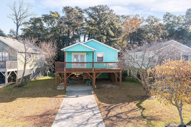 view of front of home featuring a carport, french doors, concrete driveway, and a front yard