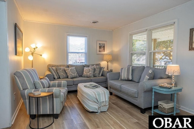 living room with visible vents, crown molding, and light wood-type flooring