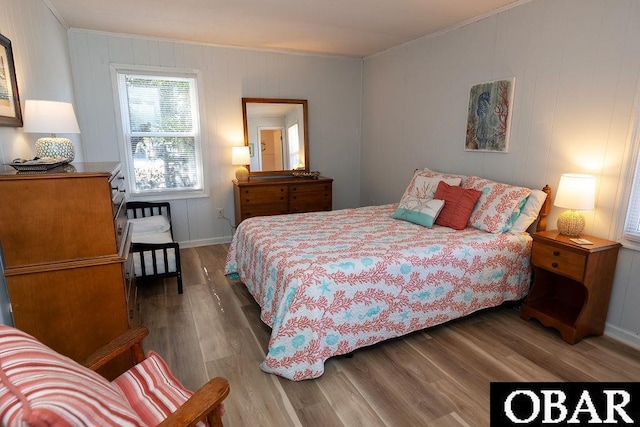 bedroom featuring wood finished floors and ornamental molding