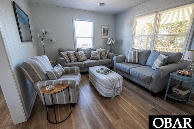 living room with visible vents, wood finished floors, and crown molding