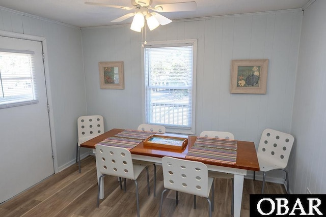 dining space featuring wood finished floors, a ceiling fan, and ornamental molding