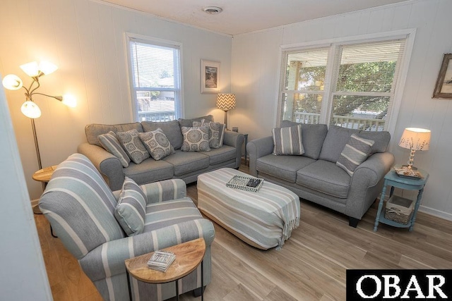 living room with visible vents, light wood-style floors, and a healthy amount of sunlight