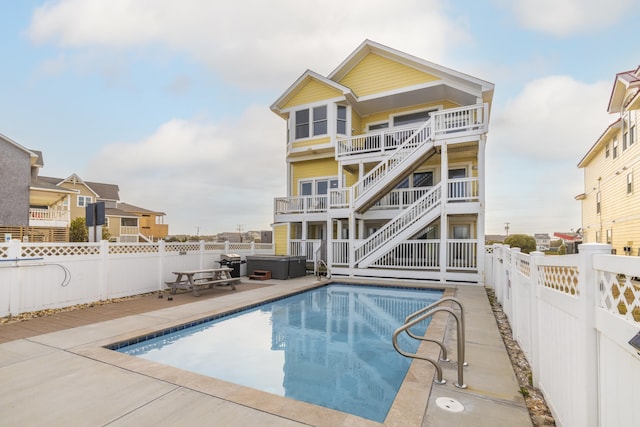 view of swimming pool with a patio, a fenced backyard, stairway, a fenced in pool, and a hot tub