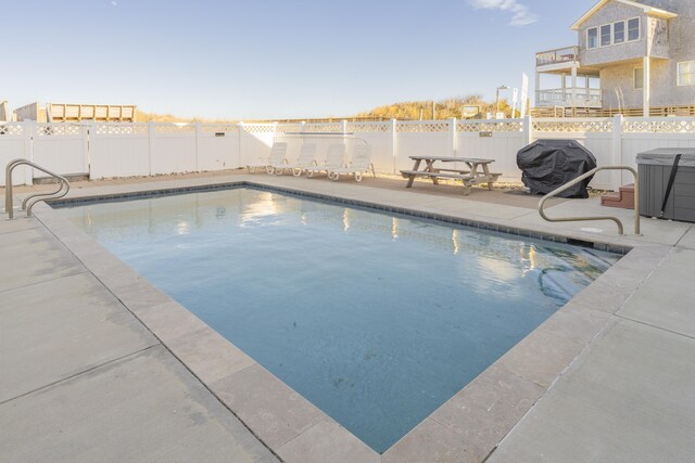 view of swimming pool featuring a patio, a fenced backyard, a fenced in pool, and grilling area