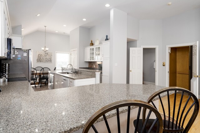 kitchen featuring dishwasher, an inviting chandelier, white cabinetry, and a sink