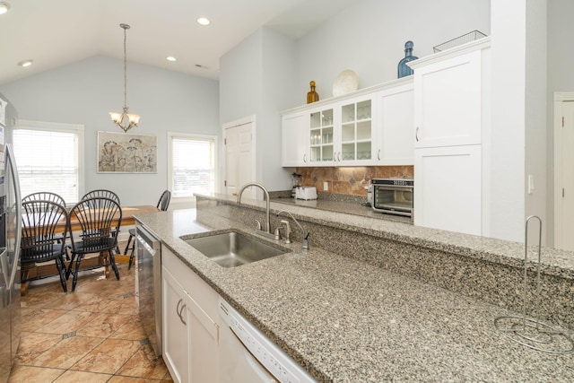 kitchen featuring glass insert cabinets, dishwasher, pendant lighting, white cabinets, and a sink