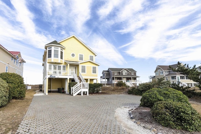 view of front of home with stairway, a residential view, and driveway