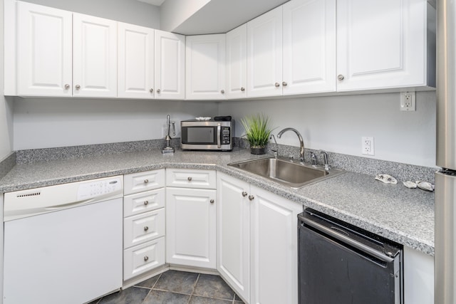 kitchen featuring a sink, appliances with stainless steel finishes, white cabinets, and light countertops