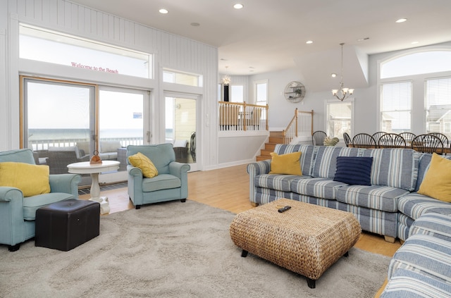 living room with stairs, a notable chandelier, wood finished floors, and recessed lighting