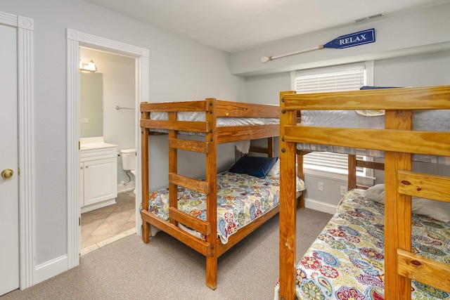 bedroom featuring visible vents, connected bathroom, and carpet