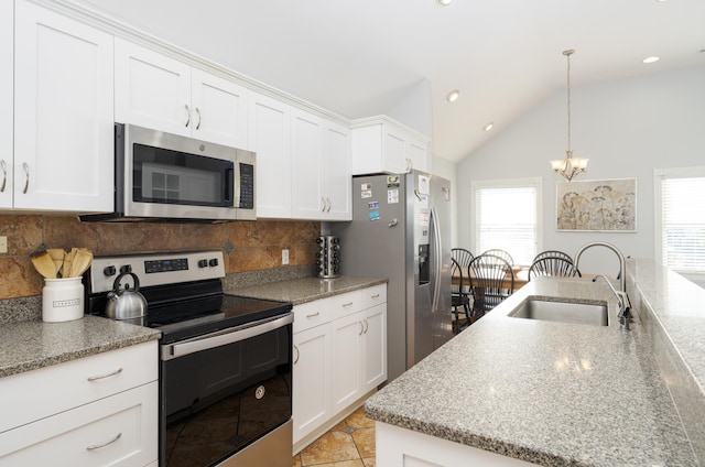 kitchen with a sink, lofted ceiling, a healthy amount of sunlight, and stainless steel appliances