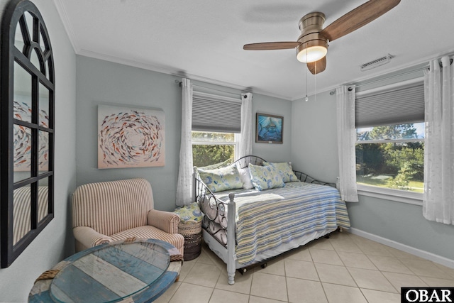 bedroom featuring light tile patterned floors, a ceiling fan, visible vents, baseboards, and ornamental molding