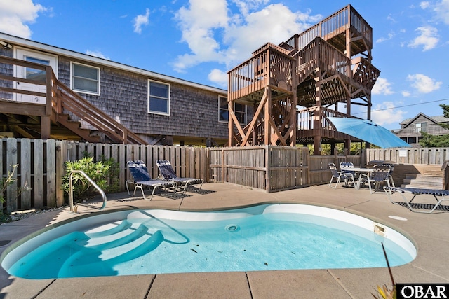 view of swimming pool featuring stairway, a patio area, fence, and a fenced in pool